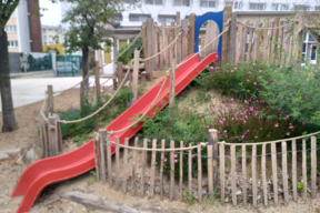 Le toboggan partant de la butte végétalisée à l'école maternelle